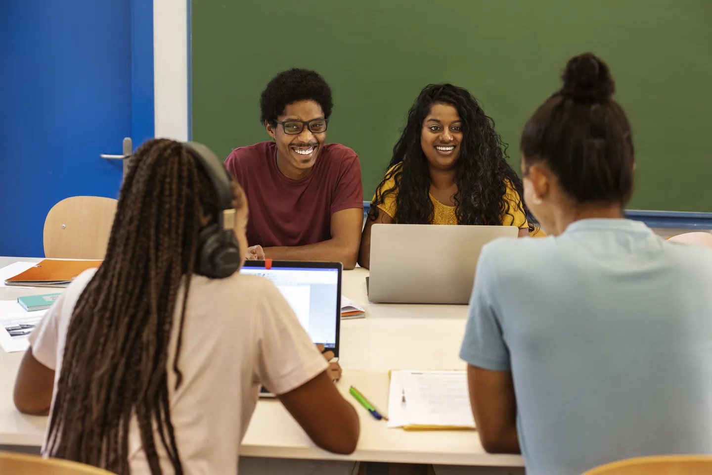 Teachers and students working together around a classroom table